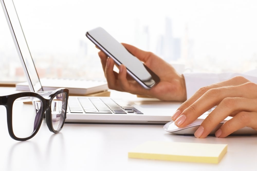 Closeup,Of,Business,Woman,Hands,Using,Cell,Phone,And,Laptop